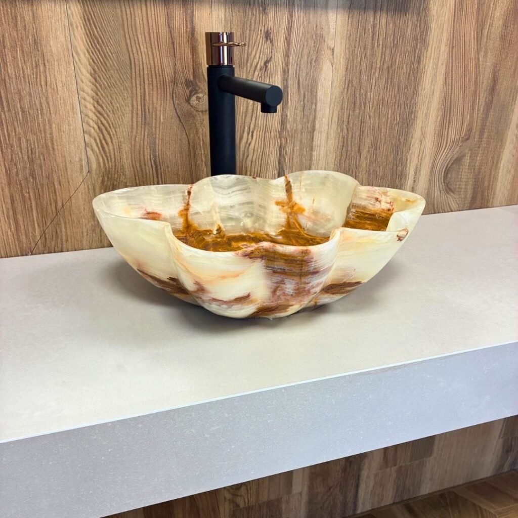 Lavabo artesanal en piedra natural ónix blanco con diseño irregular sobre encimera