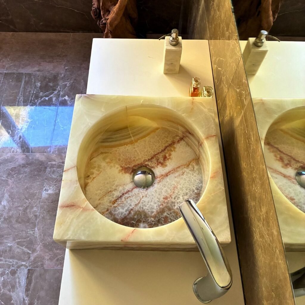 Lavabo cuadrado de ónix sobre encimera de baño moderno