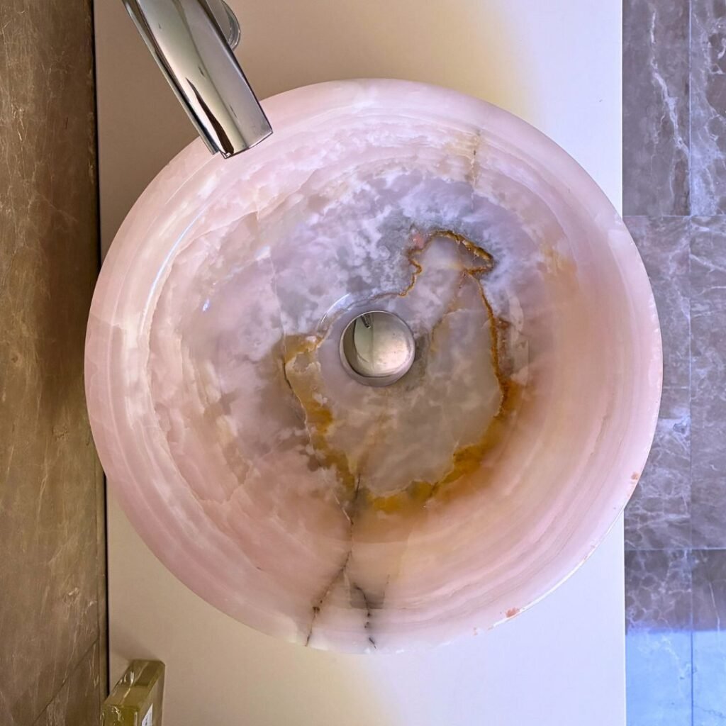 Lavabo mármol rosa artesanal tipo bowl sobre mueble de baño