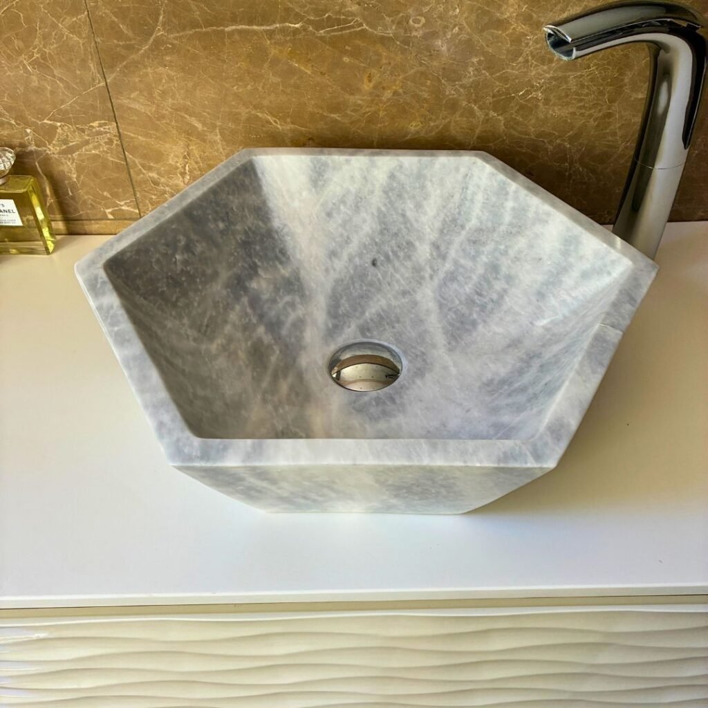 Lavamanos de mármol gris sobre encimera en baño moderno