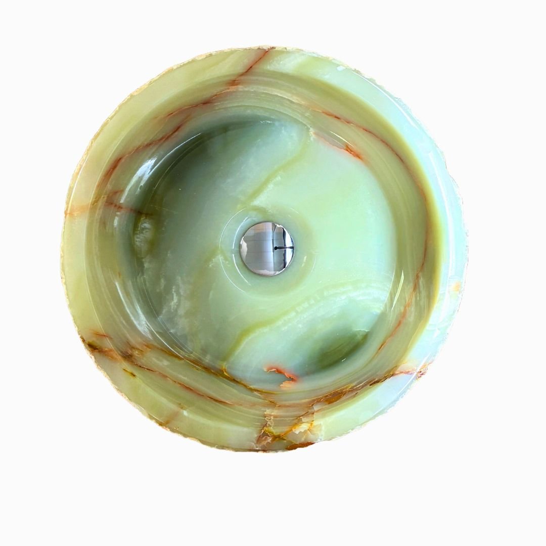 Lavabo de piedra natural onix rugoso sobre encimera contemporánea