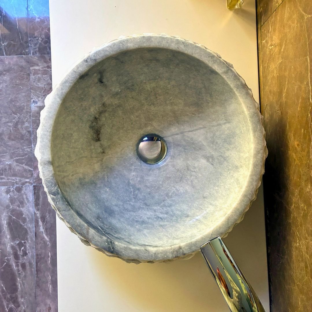 Handgefertigtes Waschbecken aus weißem Marmor im Landhausstil.