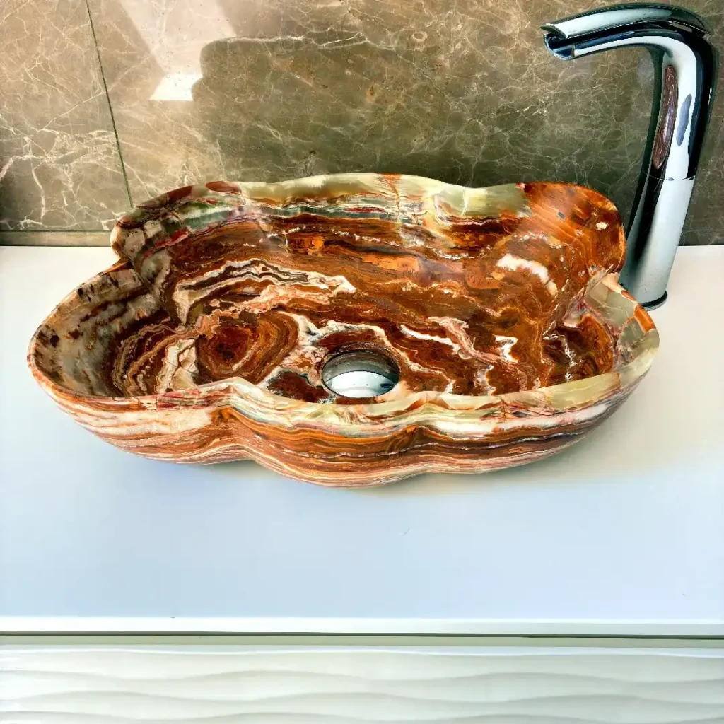 Front view of a compact onyx bathroom washbasin in brown natural stone, designed for small bathrooms, guest bathrooms and powder rooms